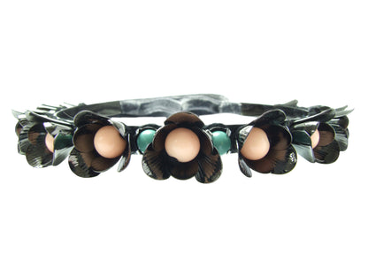 With beautiful dark finish in hematite, metal Lilly choker is embellished with flowers and pastel coloured Swarovski pearls. The choker fastens at the back with a luxurious velvet ribbon. 
